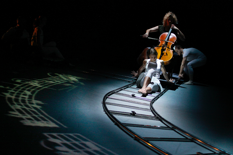 Photo of Cellist and two dancers in Desirelines